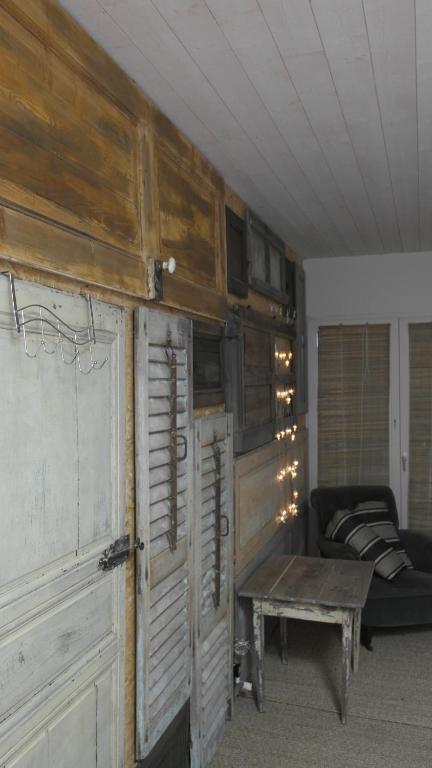 a room with wooden doors and a couch and a table at Gîte, Vintage Touch in Hannonville-sous-les-Côtes