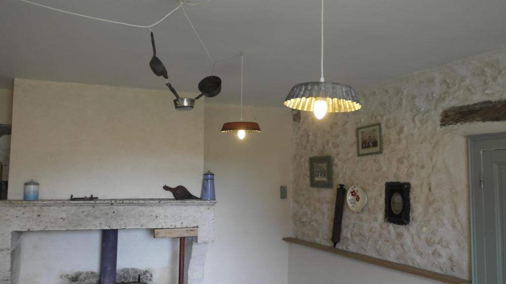 a living room with a fireplace and two lights at Gîte, Vintage Touch in Hannonville-sous-les-Côtes