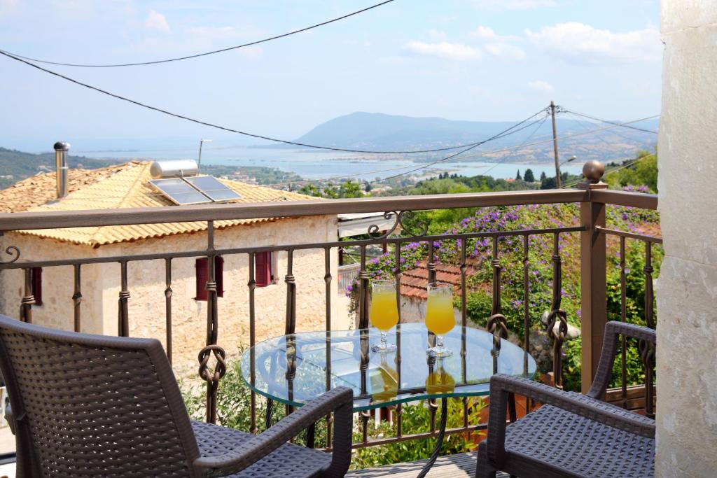 a balcony with a table with two drinks on it at Matzanas House in Katouna