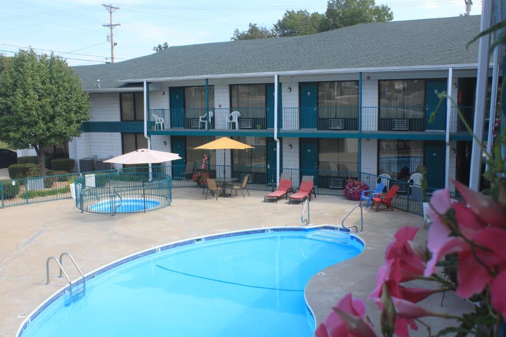 a hotel with a swimming pool in front of a building at Ozark Valley Lodge in Branson