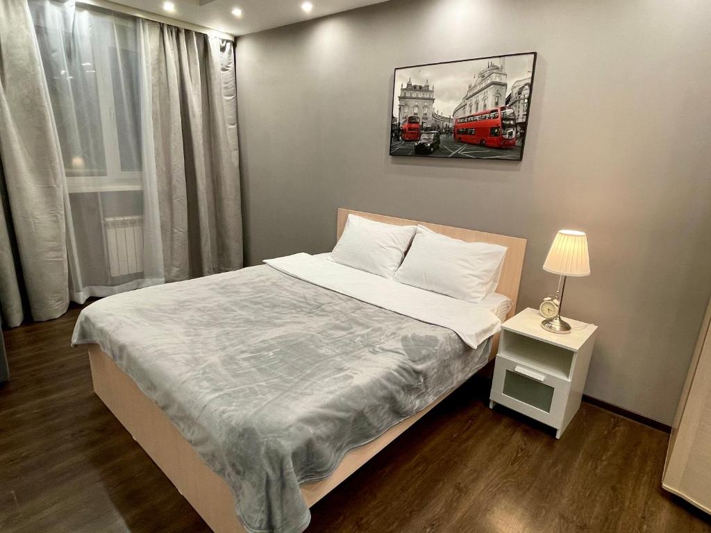 a bedroom with a bed and a picture on the wall at Apartment on Krasnoarmeyskaya in Kemerovo