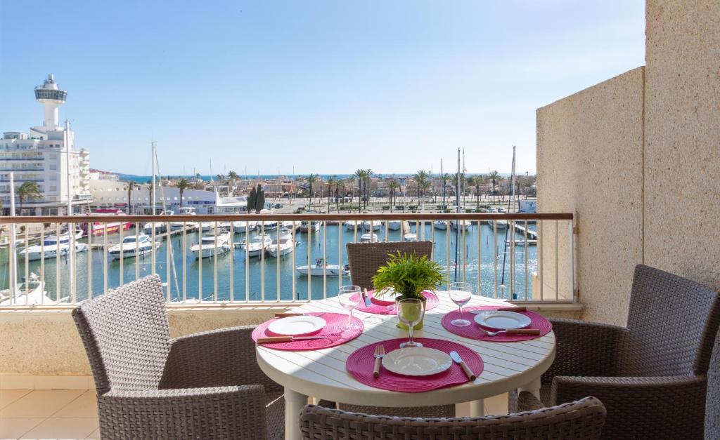 een tafel op een balkon met uitzicht op een haven bij Apart-rent Apartament Port Grec 0157 in Empuriabrava