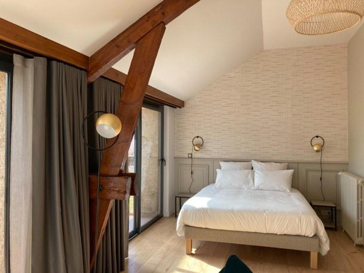 um quarto com uma cama branca e algumas janelas em Domaine Jacqueline Père & Filles em Aix-les-Bains