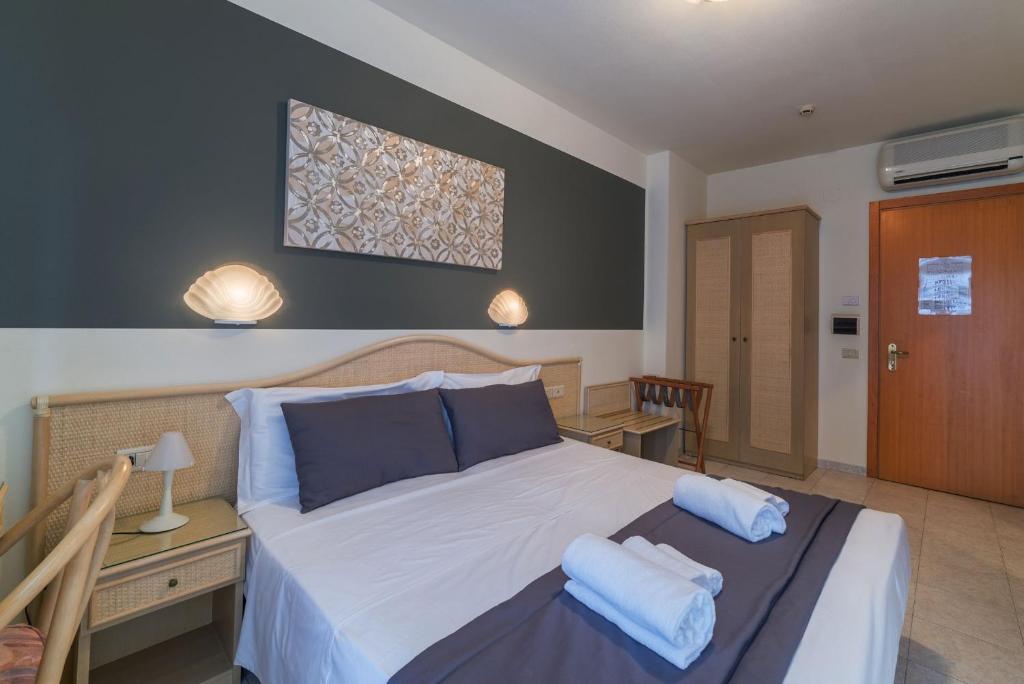 a bedroom with a large bed with blue pillows at Hotel Airone in Bibione
