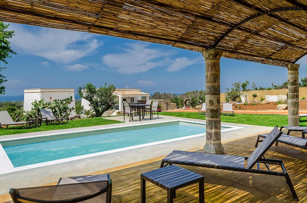 a patio with chairs and a swimming pool at Villa Torre Dell'Altomare con piscina, blocco n2 - Apulia Home in Alliste