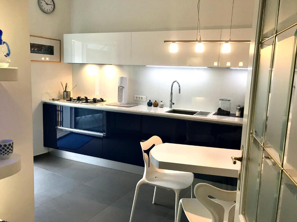 a kitchen with blue and white cabinets and a table and chairs at villa Mays in Merano