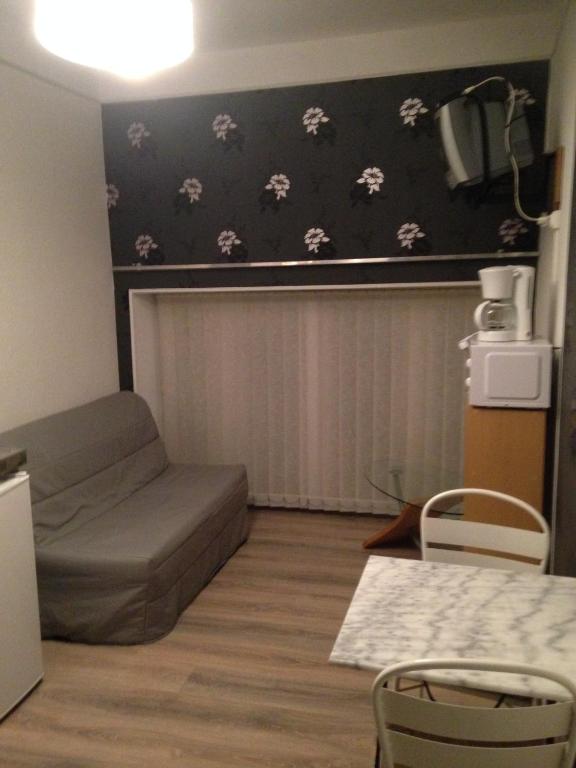 a small living room with a couch and a table at Studio le Central in Vittel