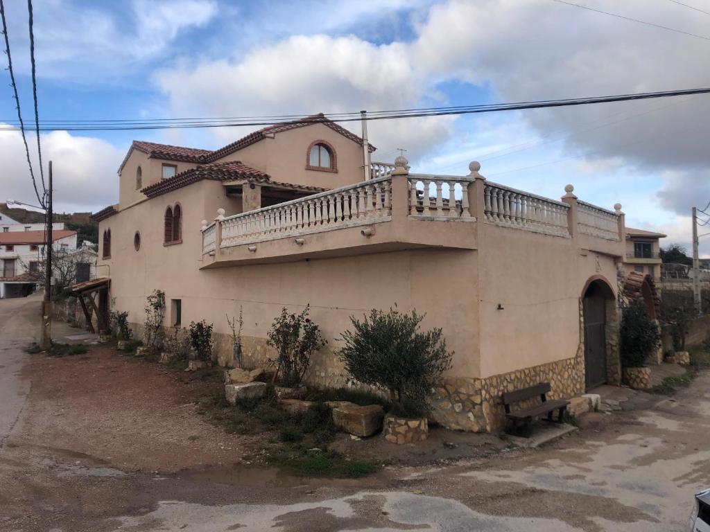 una casa con un balcón en el lateral. en Casa Rural El Huerto del Trucho, en Oliete