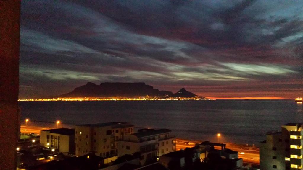 a view of the city and the ocean at night at Atlantic Haven in Bloubergstrand