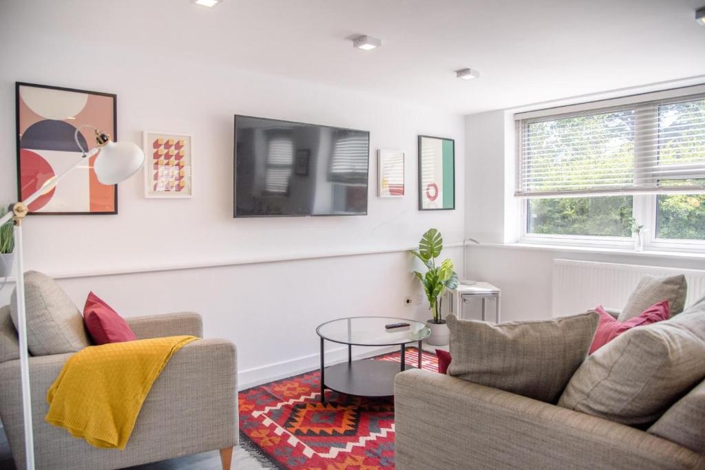 a living room with a couch and a tv at Sutton House, Woodbridge in Woodbridge