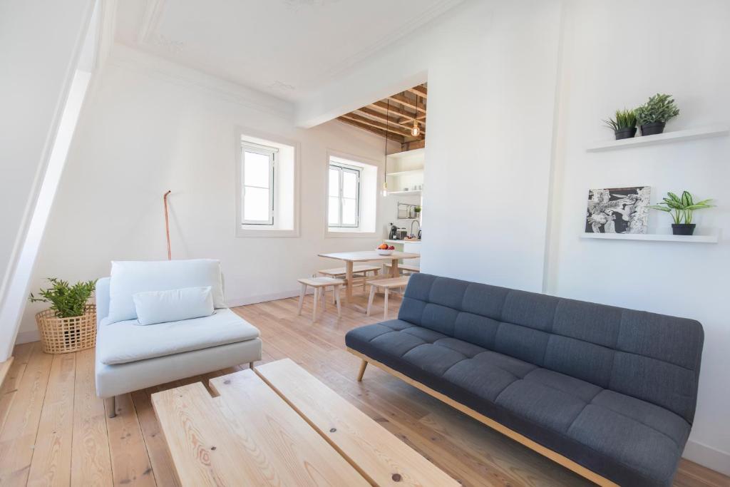 ein Wohnzimmer mit einem Sofa und einem Stuhl in der Unterkunft Historical Apartment Santos IV in Lissabon