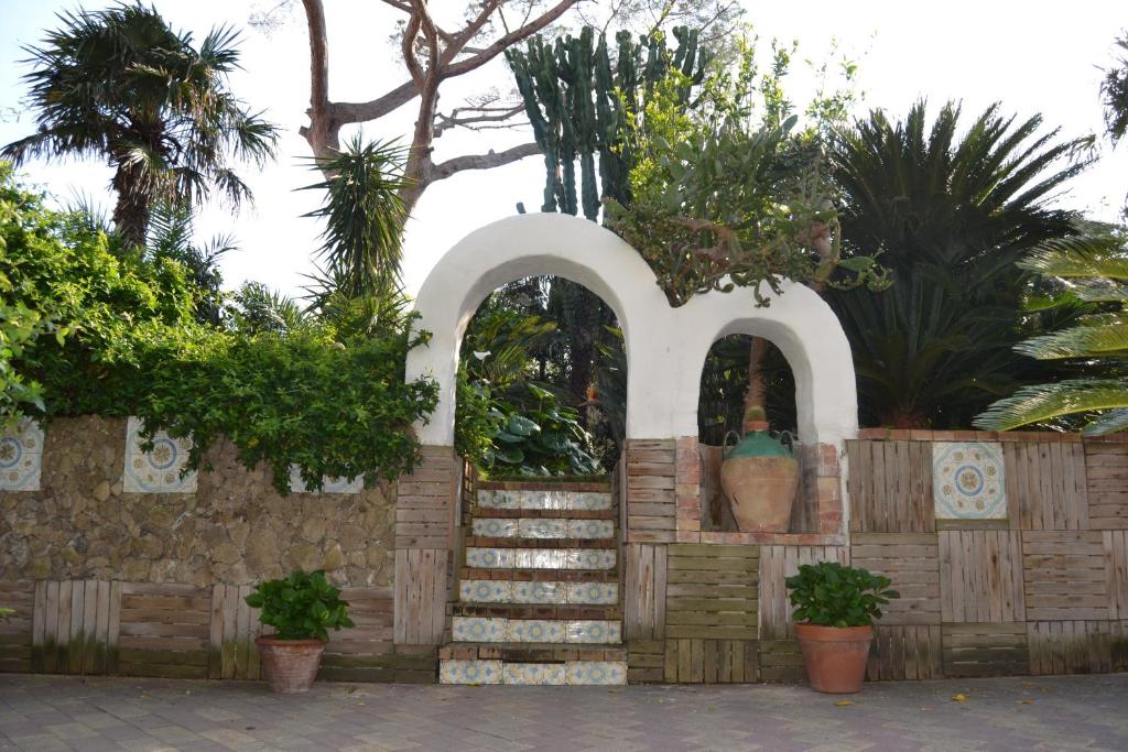 a building with a staircase and a fence with plants at Piccolo Tirreno Hotel Residence in Procida