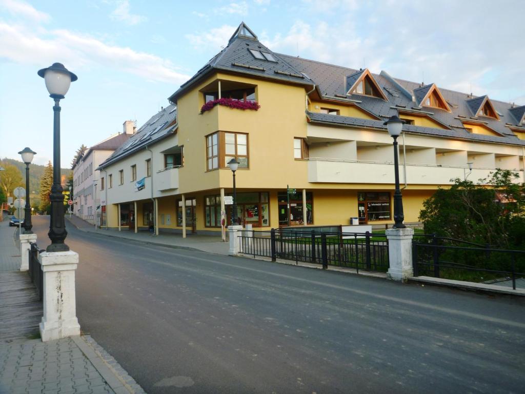 ヴェルケー・ロシニにあるApartmán Velké Losinyの通路脇の黄色い建物