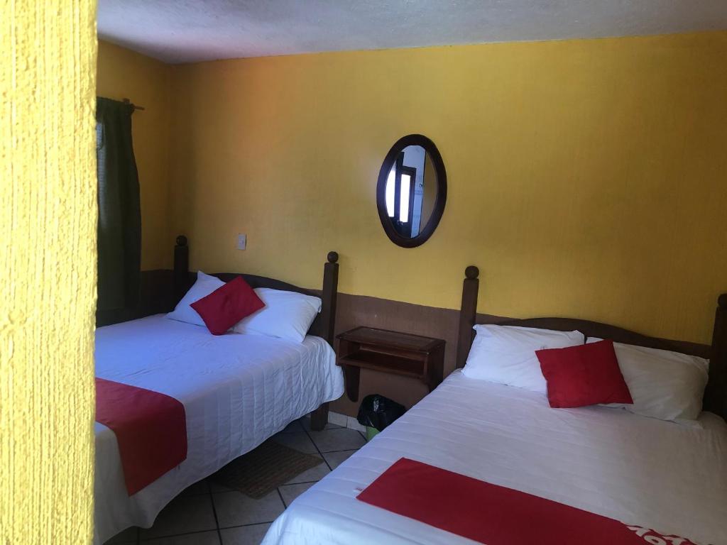 a bedroom with two beds and a mirror on the wall at San Pablo in Pátzcuaro