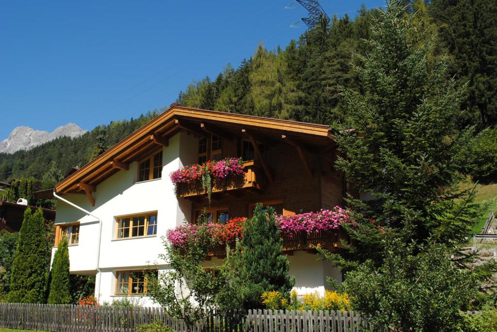 ein Haus mit Blumen auf der Seite in der Unterkunft Haus Untergand in Sankt Anton am Arlberg