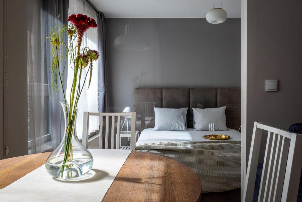wazon z kwiatami na stole w sypialni w obiekcie apartamenty-wroc Golden House we Wrocławiu