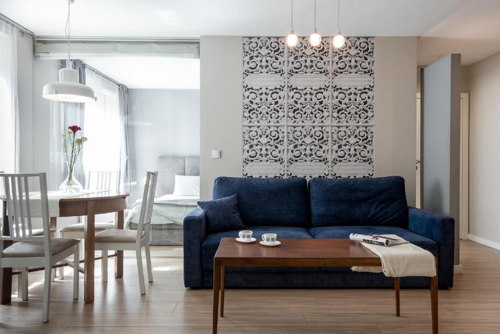 salon z niebieską kanapą i stołem w obiekcie apartamenty-wroc Golden House we Wrocławiu