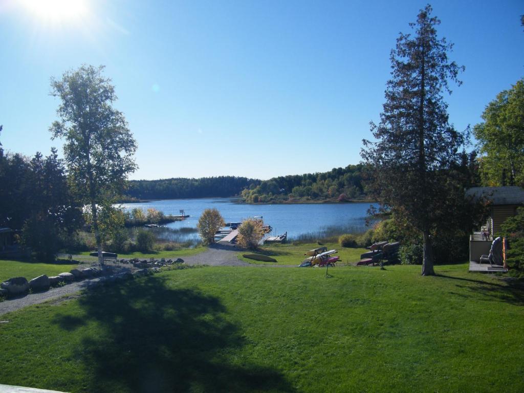 vistas a un parque con un lago en el fondo en Mowat Landing Cottages, en New Liskeard