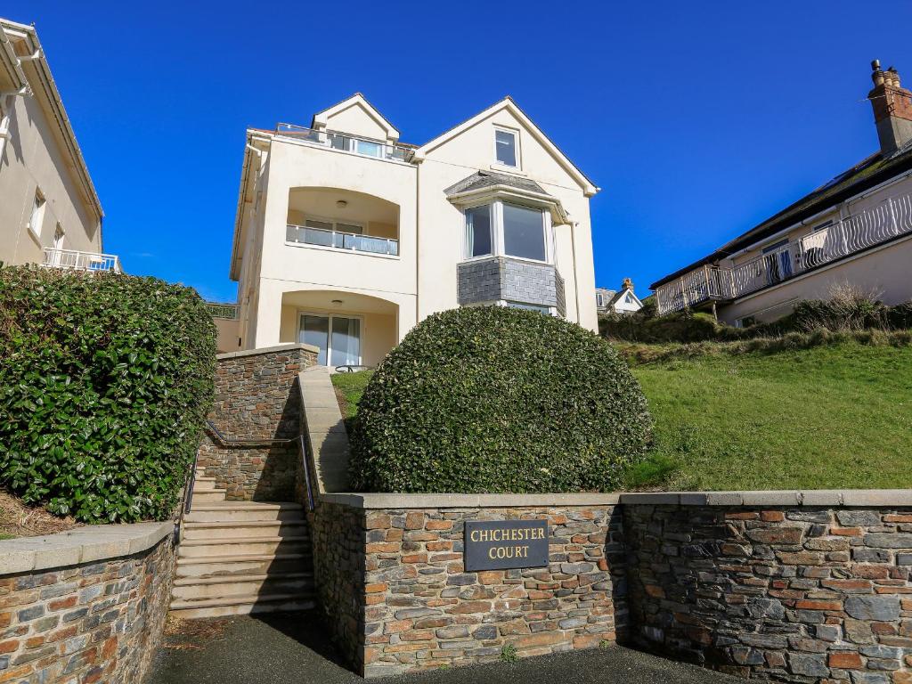 a white house with a sign in front of it at 6 Chichester Court in Hope Cove