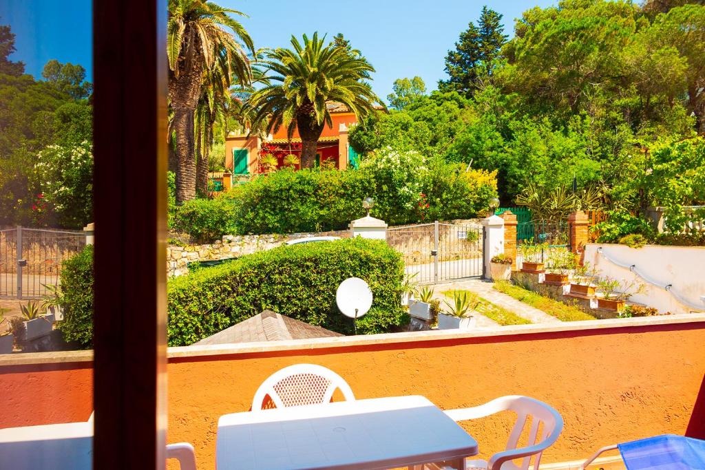 a view of a garden from a balcony with a table and chairs at Appartamento La Baia in Rio nellʼElba