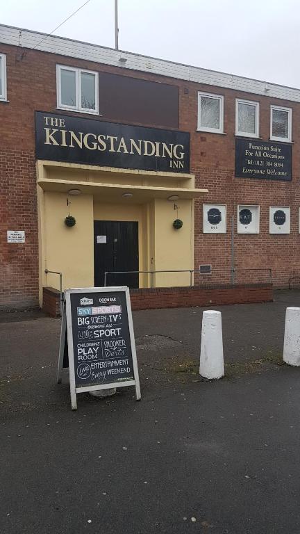 un edificio con una señal frente a un edificio en The Kingstanding Inn en Birmingham
