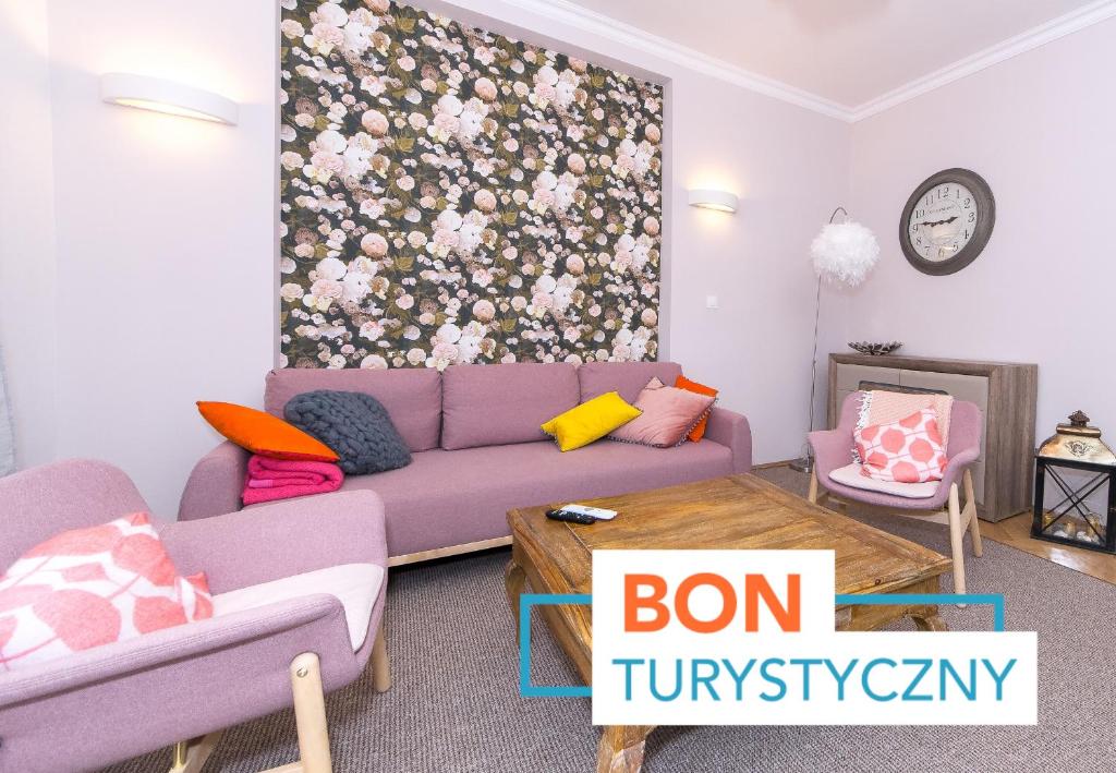 a living room with a purple couch and a floral wall at BIG APARTMENT OLD TOWN p4you pl in Kraków