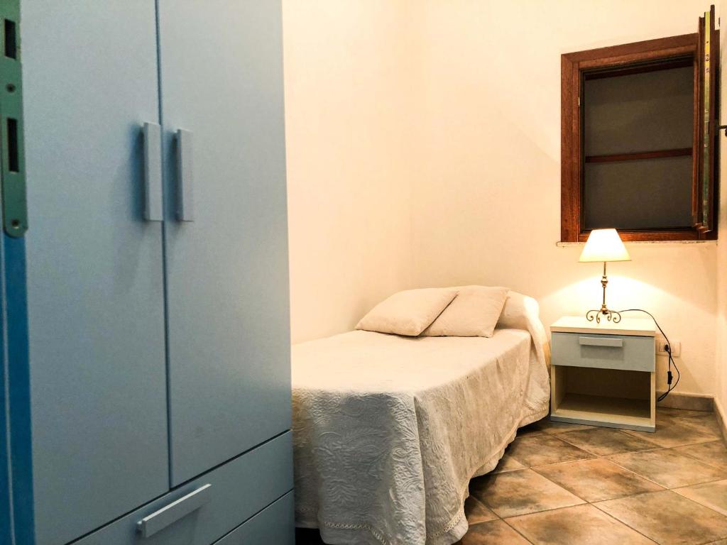 a small bedroom with a bed and a window at Sas Tilibbas-Ammentos Posada in Posada