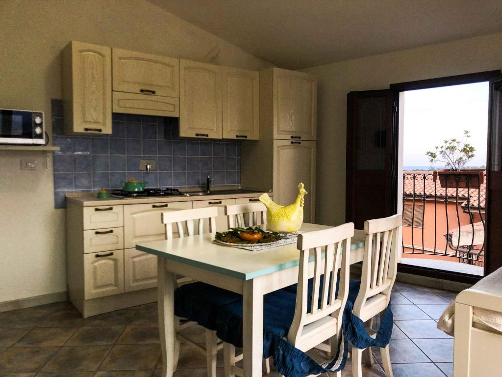 a kitchen with a table and chairs and a kitchen with a balcony at Sas Tilibbas-Ammentos Posada in Posada