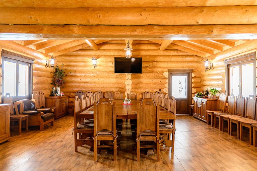 a dining room with a table and chairs at Cabana Nemtisor in Nemţişor