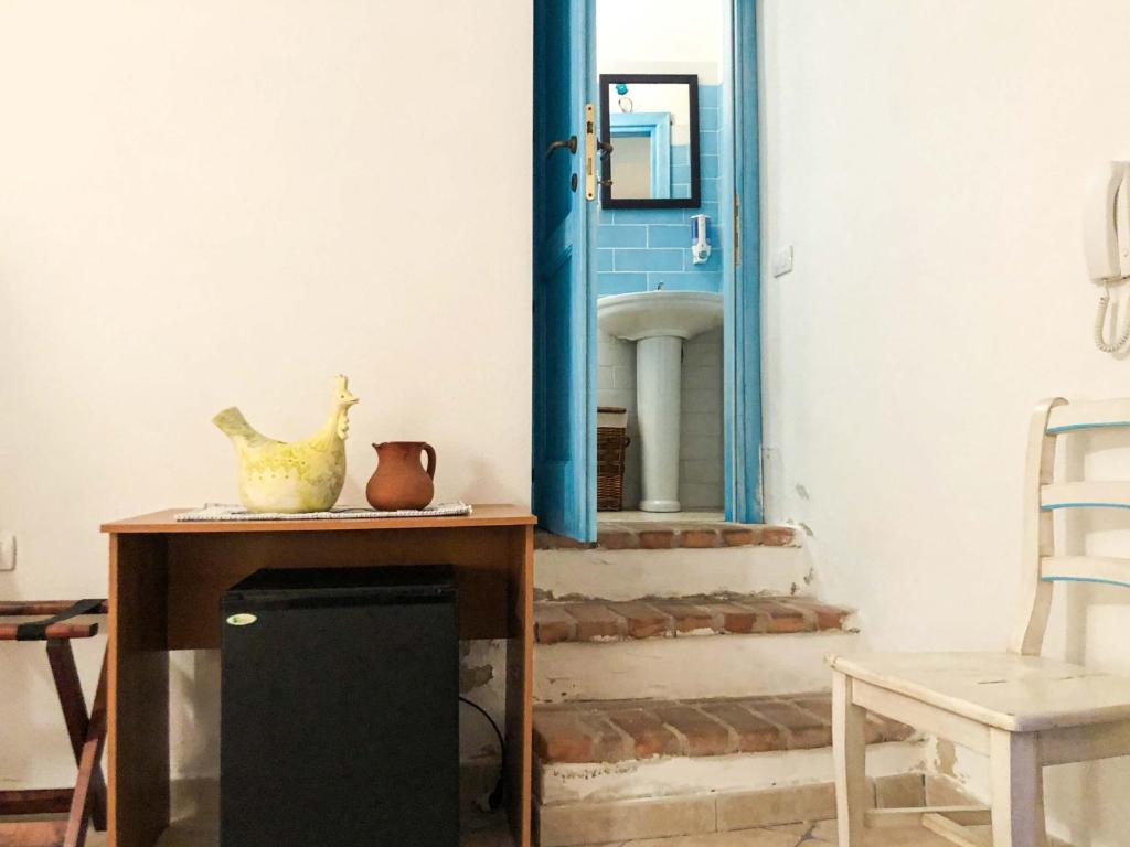 a table with a mirror and a table with a chair at Sas Tilibbas-Ammentos Posada in Posada