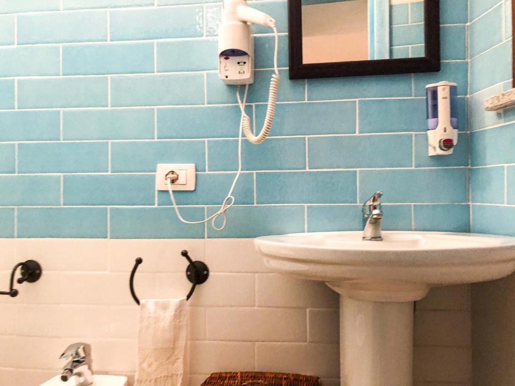 a bathroom with a sink and a mirror at Sas Tilibbas-Ammentos Posada in Posada