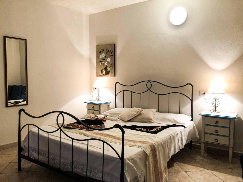 a bedroom with a large bed with two night stands at Sas Tilibbas-Ammentos Posada in Posada