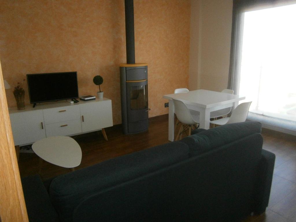 ein Wohnzimmer mit einem Sofa, einem Tisch und einem TV in der Unterkunft Apartament Ornis Duc Complexe Gorria in Sant Carles de la Ràpita