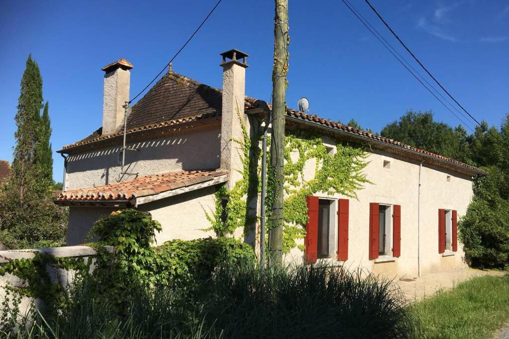 a white house with red windows and a pole at Maison de charme confortable au cœur de la nature in Saint-André-de-Double