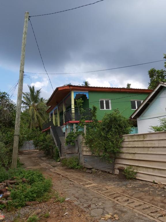 ein grünes Haus mit einem Zaun davor in der Unterkunft Ciel du sud in Mbouini