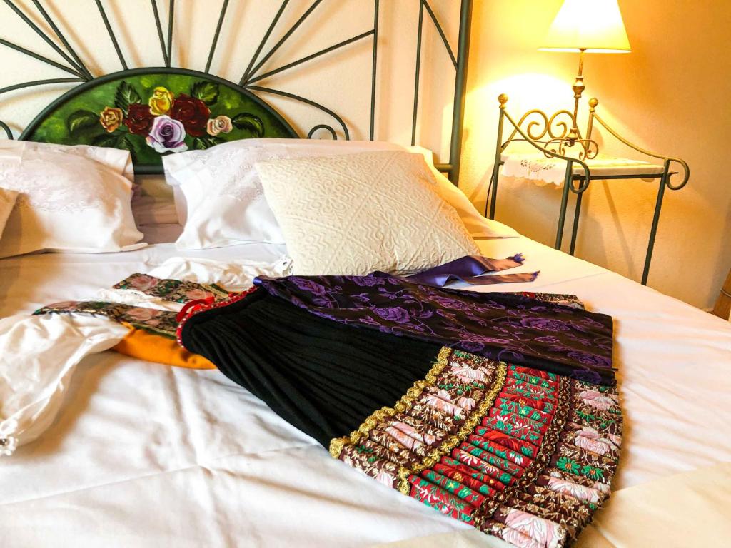 a blanket laying on top of a bed at Sas Tilibbas-Ammentos Posada in Posada