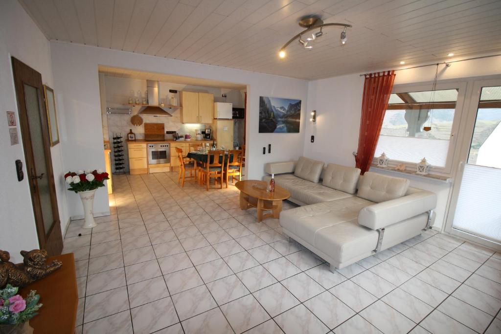 a living room with a white couch and a kitchen at Komfort Ferienwohnung FEWO74-2 in Bremm