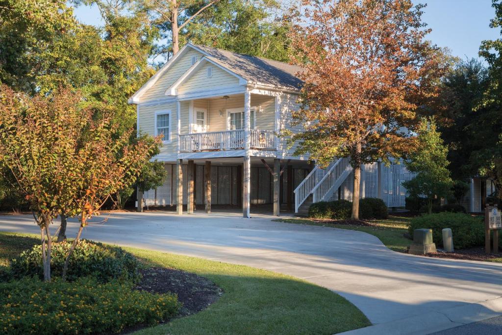 a house with a balcony on a road at Club Wyndham at The Cottages in Myrtle Beach