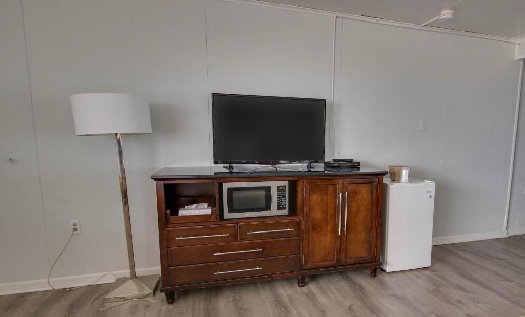 a tv on top of a wooden cabinet with a microwave at Rideau Oceanfront Motel in Ocean City