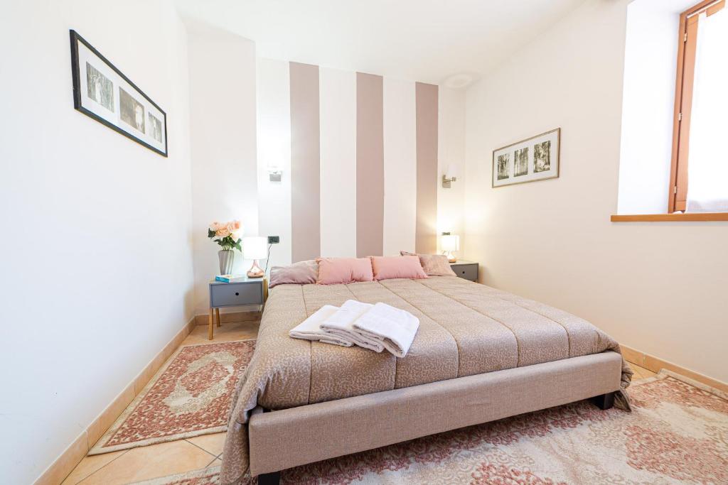 Un dormitorio con una cama y una pared rayada. en Le Muse, Comano Terme Holiday - piano terra, en Comano Terme
