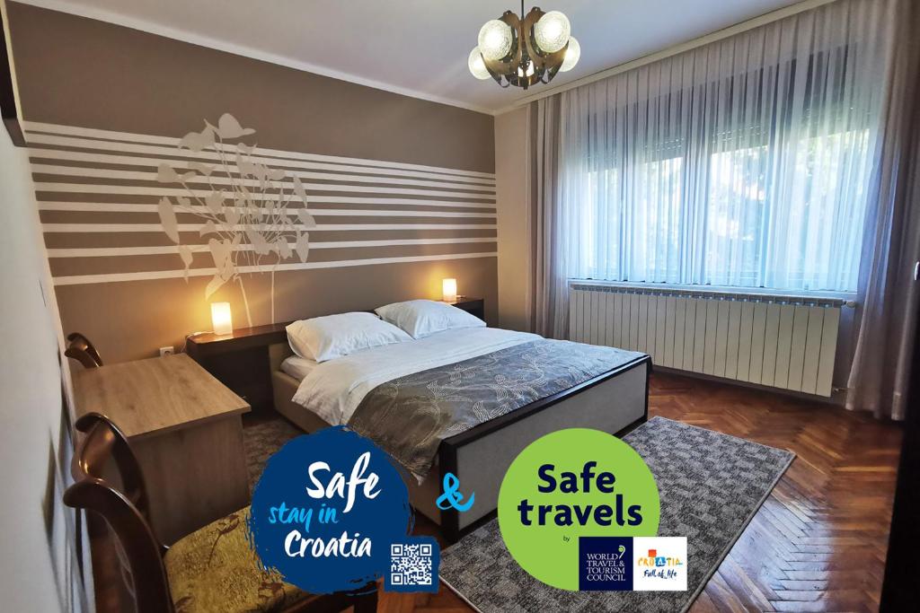 a hotel room with a bed and two stickers on the wall at Apartman Škudar in Bjelovar