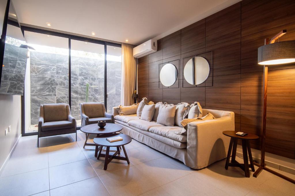 PENINSULA STAYS 2 BR Designer Apartment & 200 MB FAST WIFI New Listing! في ميريدا: غرفة معيشة مع أريكة وكرسيين