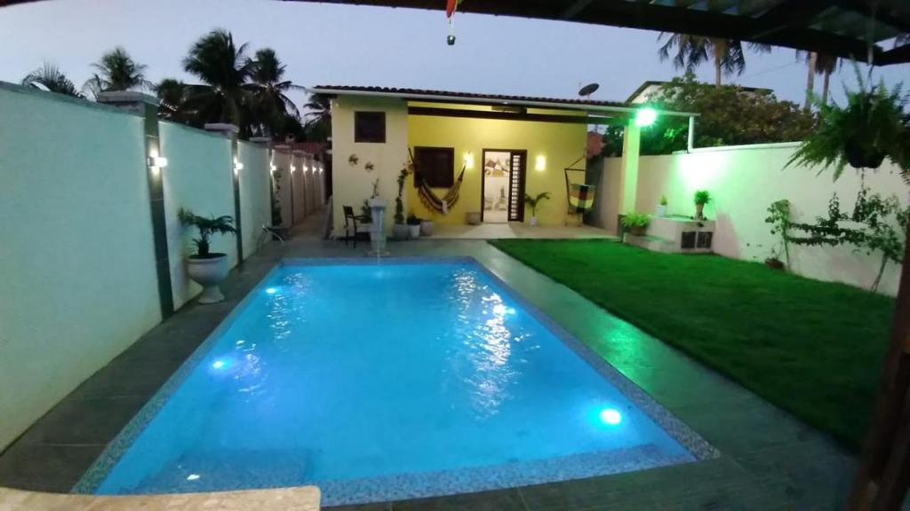 uma piscina no quintal de uma casa à noite em casa praia de guajiru em Trairi
