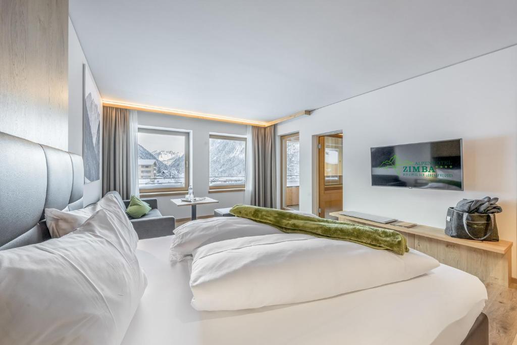 Postel nebo postele na pokoji v ubytování Alpenhotel Zimba