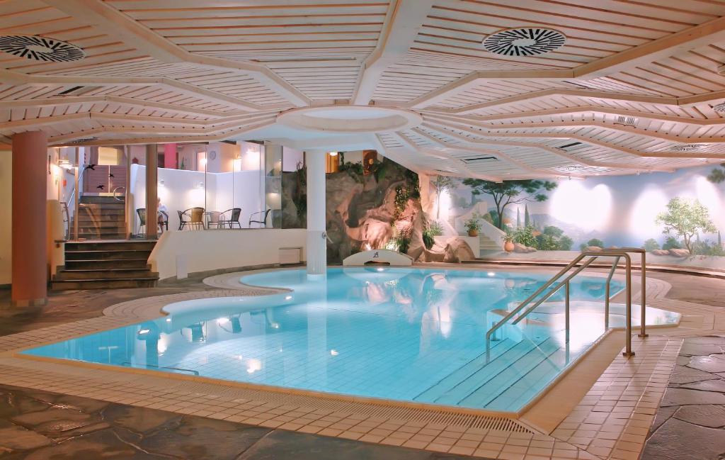 a large swimming pool in a hotel with a ceiling at Villa Huxori in Höxter