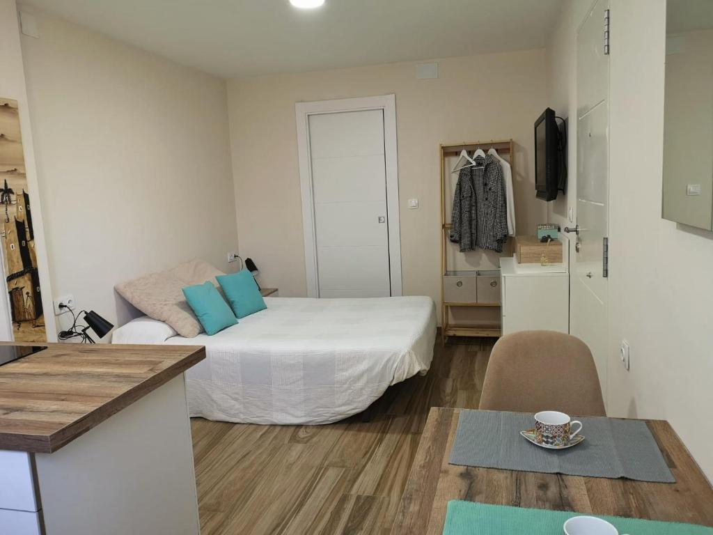 um pequeno quarto com uma cama com almofadas azuis em Apartamento acogedor en Granada em Granada