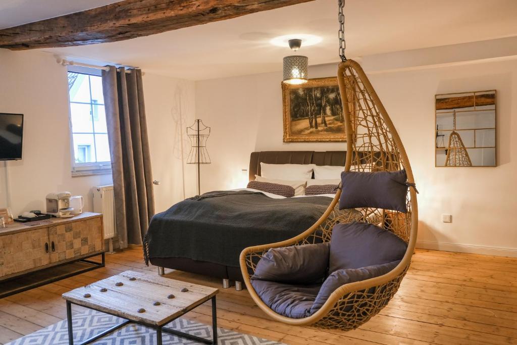 um quarto com uma cama e uma cadeira suspensa em Boutique Hotel Marielle em Bad Münstereifel