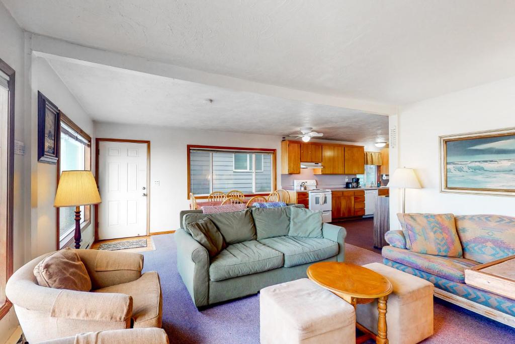 a living room with two couches and a table at The Hideout in Rockaway Beach