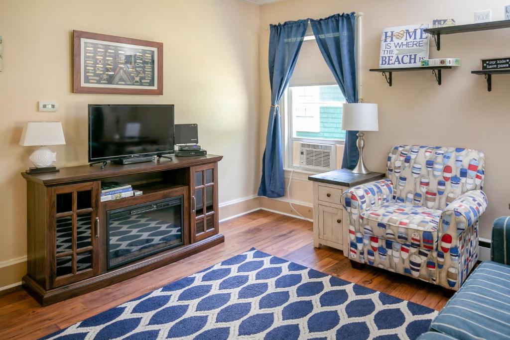 un soggiorno con TV e sedia di Norris Cottage a Bar Harbor