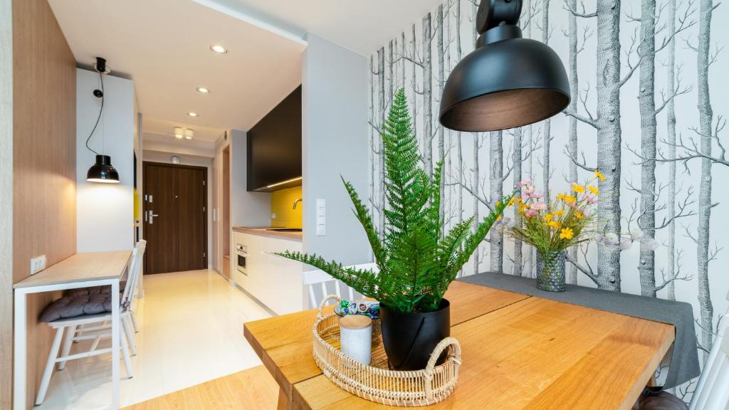 a dining room with a table with a plant on it at Triventi Mountain Residence Apartament Sunrise in Karpacz